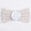 Detalle de la diadema de punto para bebé en color crema con una delicada flor blanca - Beige