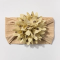 Close-up of beige knitted baby headband featuring a large polka dot fabric flower detail - Light Coffee