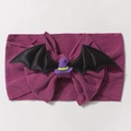 Dettaglio della fascia neonata viola in maglia con ali di pipistrello e cappello da strega - Viola intenso