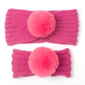 Detail of rose pink cable knit parent-child headband set with large matching faux fur pompoms - Two-Piece Set / Rose Red