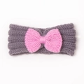 Dettaglio della fascia per neonati in maglia grigia con fiocco rosa e morbida lana - Grigio + Rosa