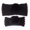 Detail of parent-child black knitted headbands with large fluffy faux fur pom-poms - Black