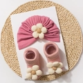 Detailed view of baby floral headband and ribbed socks set on a natural straw mat - Dusty Pink