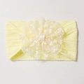 Détail d'un bandeau bébé en jacquard jaune vif orné d'une grande fleur en dentelle blanche - Poche zippée