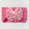 Gros plan d'un bandeau rose pour bébé en nylon jacquard avec un grand nœud en dentelle - Rouge Rose