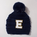 Detail of navy knit baby beanie with large pompom and gold sequin letter E patch - Navy Blue