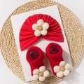 Detailed view of baby red turban hat and socks set with beige fabric flower accents - Red