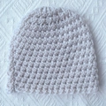 Detailed close-up of chunky knit pattern on a warm winter beanie for babies - Beige