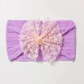 Détail d'un bandeau bébé en nylon avec grand nœud en dentelle rose et texture violette côtelée - Violet