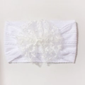 Close-up of white baby lace headband with knit texture and decorative bow details - White