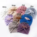Detail view of nine colored knit cotton baby beanies with cute puppy patches and ribbed design - 9 Colors Mixed