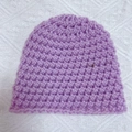 Detail view of light purple hand-crocheted baby beanie with thick knit texture and soft yarn - Purple