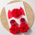 Detail view of red baby floral headband and socks set on a circular woven mat - Red