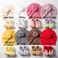 Flat lay of soft knit baby hat and sock sets in eight colors with cute animal dolls - Multicolor