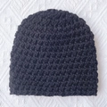 Detailed macro view of black chunky knit baby beanie texture for winter warmth - Black
