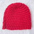 Detailed view of handmade chunky red knit baby beanie with textured crochet pattern - Red