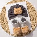 Detail of dark grey baby hat and socks set featuring cute brown plush bear decorations - Gray