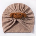 Detailed view of knitted infant turban featuring a brown plush puppy embroidery on soft khaki - Coffee