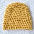 Close-up of bright yellow chunky knit baby hat with thick honeycomb texture pattern - Yellow