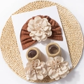 Detailed view of ribbed baby headband and socks with large floral fabric embellishments - Brown