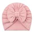 Close-up detail of soft pink knitted baby turban with large bow and textured jacquard pattern - Snow Bud