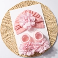 Detail van de roze gebreide baby muts en sokken set met handgemaakte bloemdecoratie - Sneeuwknop
