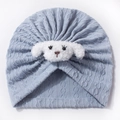 Dettaglio del cappello neonato azzurro lavorato a maglia con viso di cucciolo in peluche - Blu
