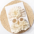 Detail van baby muts en sokken set in crème breisel met 3D stoffen bloemaccenten - Beige