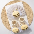 Detail view of knitted baby hat and socks set featuring cute plush bee decorations - Beige