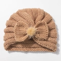 Detailed view of khaki knit baby hat with bow and fluffy pom-pom for winter - Coffee