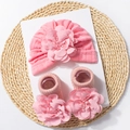 Gedetailleerde weergave van roze gebreide babysethat en sokken met grote 3D-stoffen bloemen - Roze