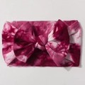 Detailed top view of a large fuchsia and white tie-dye bow on a soft nylon baby headband - Taro Purple