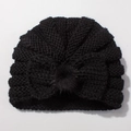 Detailed close-up of a black knit baby turban hat with a large bow and faux fur pompom - Black