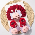 Detail of red knitted baby hat and socks set featuring cute plush bee decorations - Red