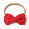 Detail of red knitted bow baby headband with elastic nylon band on white background - Red