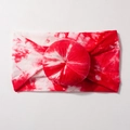Detailed view of red and white tie-dye baby headband with a soft donut knot decor - Red