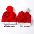 Detailed view of red Christmas knit baby hats with contrasting white and red pom-poms - Mixed Colors