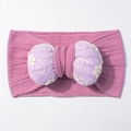Detailed close-up of stretchy knit baby headband with embroidered purple bow and floral patterns - Taro Purple