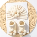 Creamy white baby set with waffle knit hat and floral socks on straw mat decoration - Beige