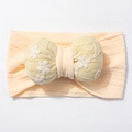 Detail of baby headband featuring soft ribbed pink fabric and embroidered yellow bow - Nude Pink