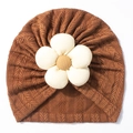 Detailed close-up of a brown knit baby turban with a 3D floral decoration - Coffee