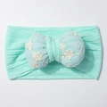 Macro shot of mint green elastic baby headband with blue floral embroidered bow detail - Mint Green