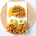 Details zum gelben Baby-Stirnband und Socken-Set mit schwarzen Herz-Blumenmustern - Erdgelb