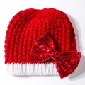 Detail van een rode gebreide kerstmuts voor baby's met een grote rode pailletten strik - Rood