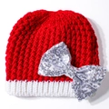 Detail van rood-witte gebreide babymuts met een grote zilverkleurige strik van lovertjes - Wit