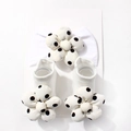 Detail view of baby elastic headband and socks set with black and white polka dot flowers - White