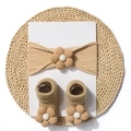Detailed view of baby headband and socks set with 3D floral knit textures in warm brown - Light Coffee
