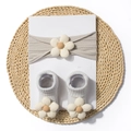 Close-up of light grey knit baby headband and socks set with cream floral accents - Gray