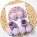 Dettaglio del set neonato con turbante viola e calzini con fiocco ricamato su paglia - Set Berretto e Calzini / Viola Taro