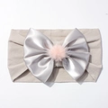 Détail d'un bandeau bébé en nylon élastique avec nœud satin gris et pompon rose - Gris